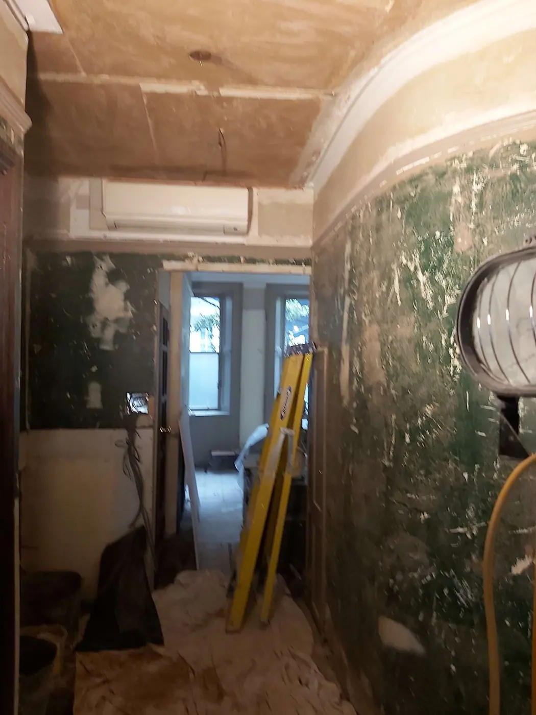The curved wall stripped back, with lights and levels on site